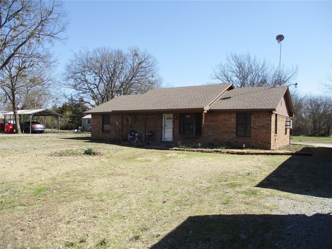 Ranch-style home featuring driveway, a shingled roof, a front lawn, a carport, and brick siding | Image 18