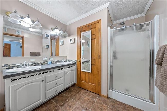 Full bath featuring a sink, ornamental molding, and a stall shower | Image 22