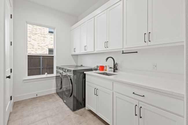 Laundry area featuring cabinet space, washer and dryer, and light tile patterned floors | Image 14
