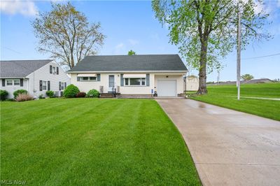 View of front facade with a garage and a front lawn | Image 1