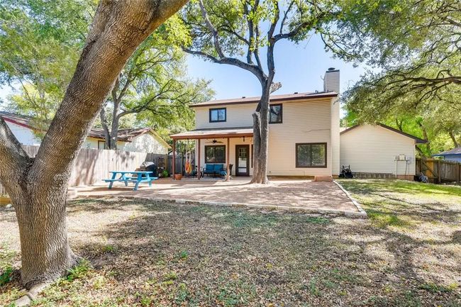 Rear view of house with a chimney, a patio area, a fenced backyard, and a ceiling fan | Image 26