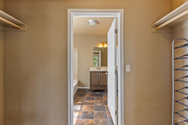 Walk in closet with dark stone finish floors | Image 25