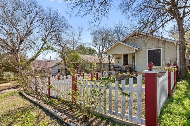 View of front facade with a fenced front yard, covered porch, and a gate | Image 31
