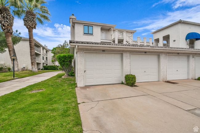 Townhome / multi-family property with stucco siding, a balcony, a front lawn, and a chimney | Image 28