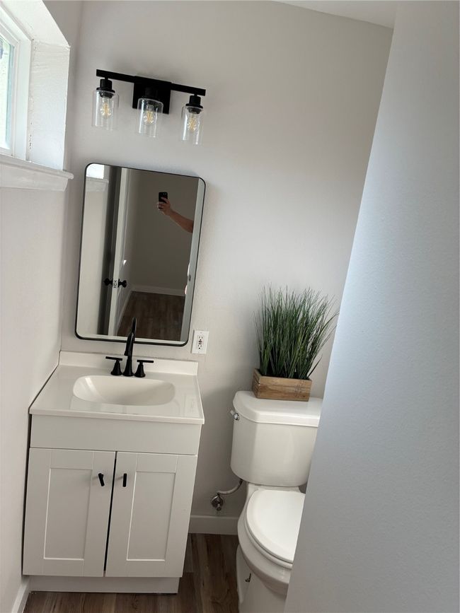 Half bathroom with wood finished floors, toilet, vanity, and baseboards | Image 13