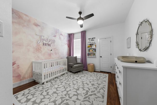 Bedroom featuring wood finished floors, ceiling fan, baseboards, and a crib | Image 26