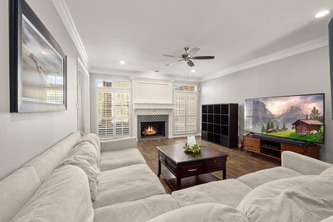 Homeowner added recess cans, new ceiling fan, and a fun tile on the fireplace. Gas logs fireplace will be the focal point for your holiday decor and is flanked by sun-filled windows with shutters. | Image 13