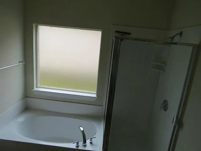 Bathroom featuring a shower stall and a garden tub | Image 9