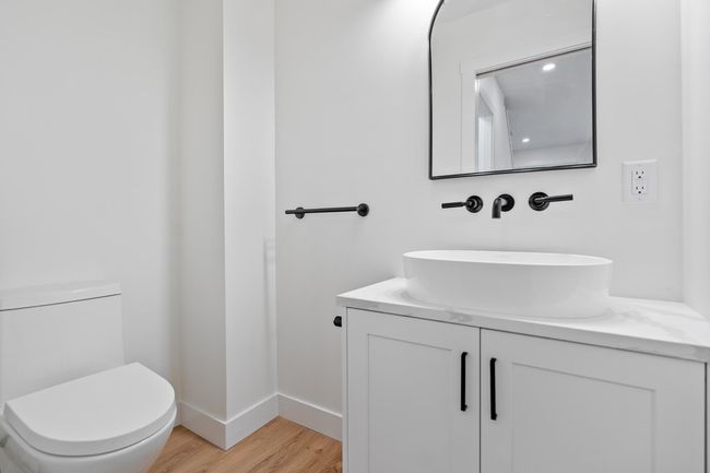 Half bath featuring baseboards, toilet, wood finished floors, and vanity | Image 6