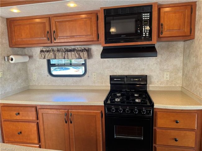 Kitchen with exhaust hood and black appliances | Image 24