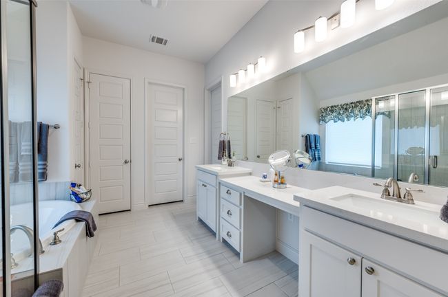 Full bathroom with a stall shower, double vanity, a bath, and a closet | Image 17