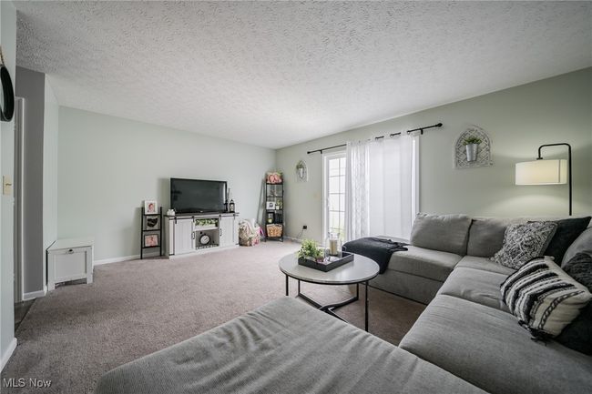 Living room featuring carpet flooring and a textured ceiling | Image 12