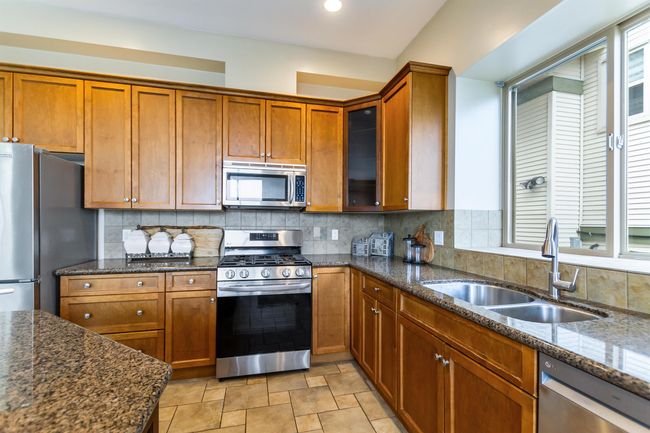 Kitchen with brown cabinets, stainless steel appliances, and a sink | Image 10