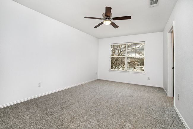 Carpeted Bedroom featuring baseboards, ceiling fan, and walk in closet. | Image 24