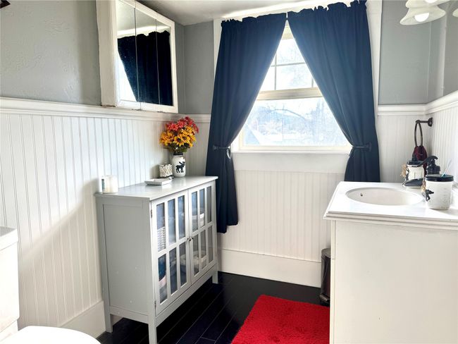 Bathroom with wood finished floors, vanity, and wainscoting | Image 23