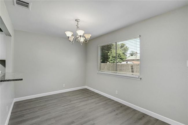 Unfurnished dining area with a chandelier, baseboards, and wood finished floors | Image 7