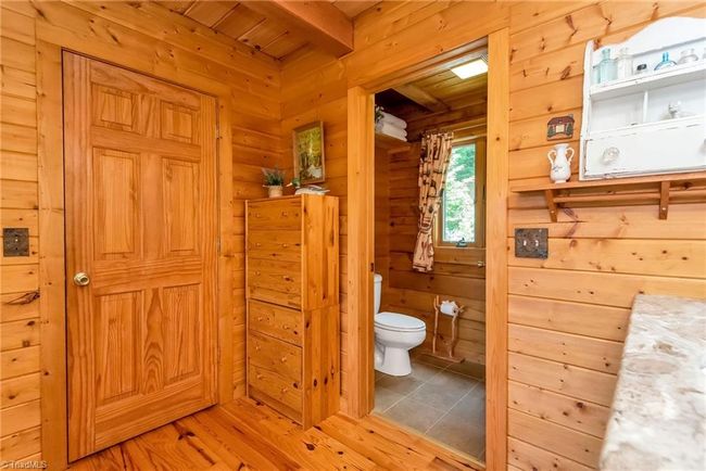 The upper-level bedroom in the log cabin offers captivating mountain views, providing a tranquil retreat amidst the rustic charm of the countryside. | Image 31