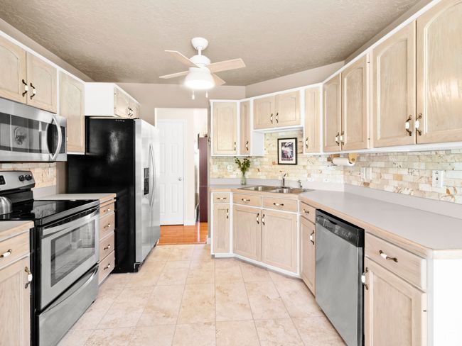 Kitchen featuring appliances with stainless steel finishes, light brown cabinets, and a ceiling fan | Image 7