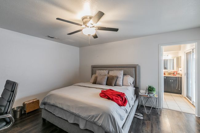 Unit 4900 Another View of Primary Bedroom with hardwood / wood-style flooring, ceiling fan, and ensuite bathroom | Image 14