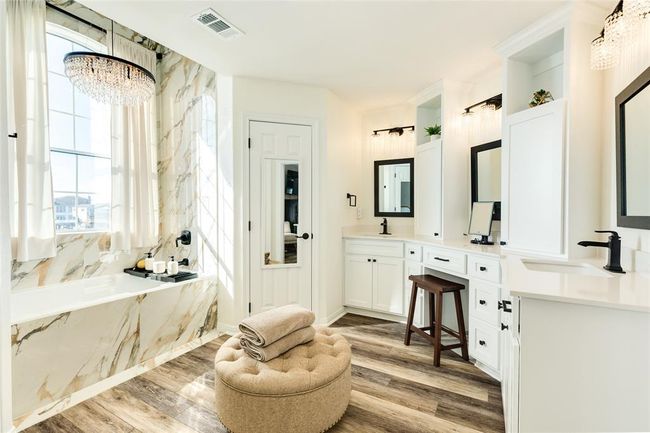 Luxurious Primary Bathroom has a large double vanity plus make-up counter. Soaking tub with chandelier and tile which extends up to the vaulted ceiling will make you feel like you're in a spa | Image 34