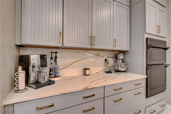 Kitchen with built in oven & microwave, gray cabinetry, tasteful backsplash, and light stone countertops | Image 26
