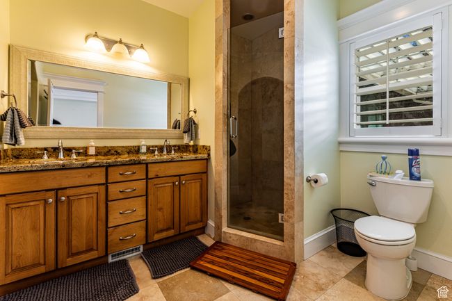 Full bath with toilet, baseboards, a shower stall, a sink, and double vanity | Image 13