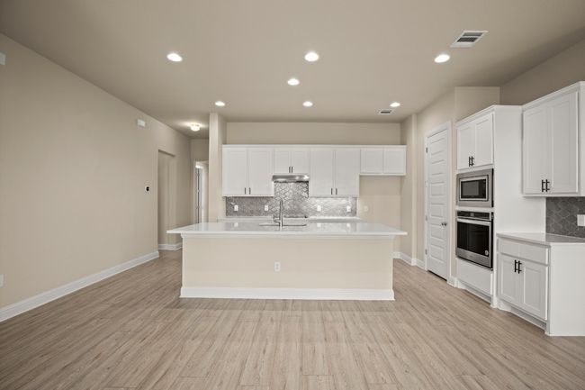 Kitchen featuring a sink, stainless steel appliances, visible vents, under cabinet range hood, and tasteful backsplash | Image 5