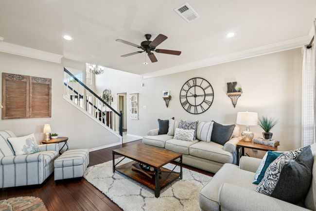 Living room featuring ornamental molding, stairway, dark wood-style floors, ceiling fan, and recessed lighting | Image 8