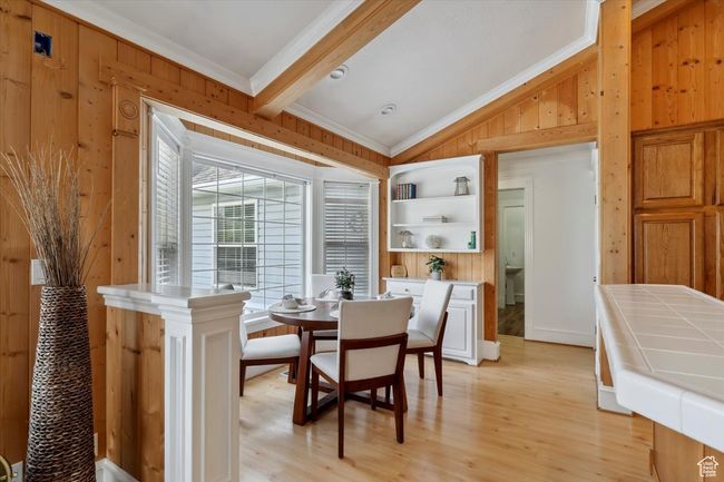 Dining space featuring wooden walls, ornamental molding, and light wood finished floors | Image 8