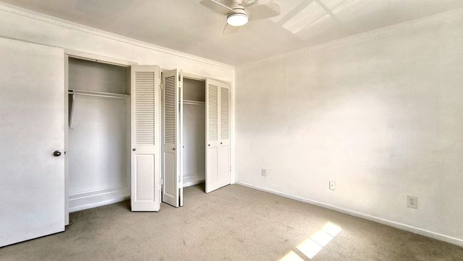 Unfurnished bedroom featuring multiple closets, carpet floors, and ceiling fan | Image 26