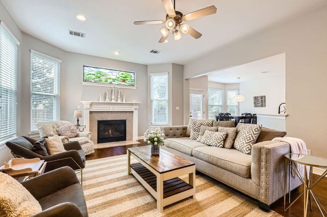Living room featuring hardwood flooring, ceiling fan, a fireplace, recessed lighting | Image 4