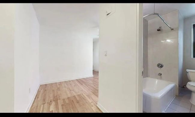 Full bathroom featuring toilet, bathtub / shower combination, and wood finished floors | Image 7