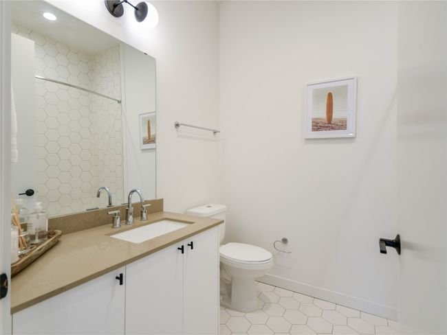 Full bath featuring baseboards, toilet, tile patterned floors, vanity, and a shower | Image 18