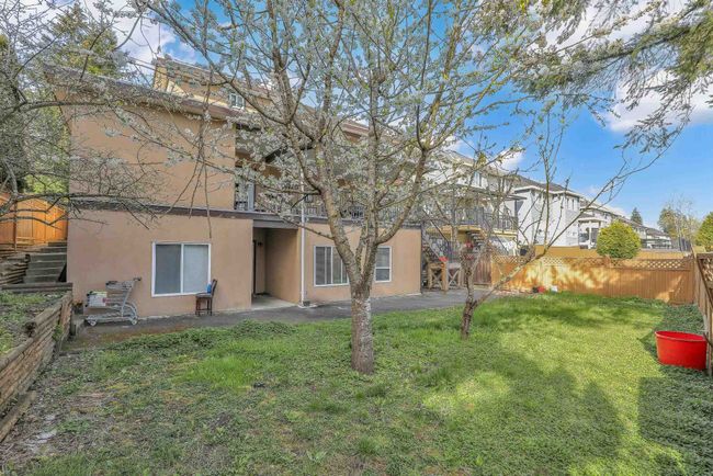 Back of property with a fenced backyard, stucco siding, and a lawn | Image 37