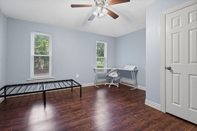 Office space with plenty of natural light, wood finished floors, and a ceiling fan | Image 16