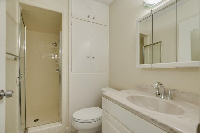 Bathroom with a shower stall, toilet, and vanity | Image 11