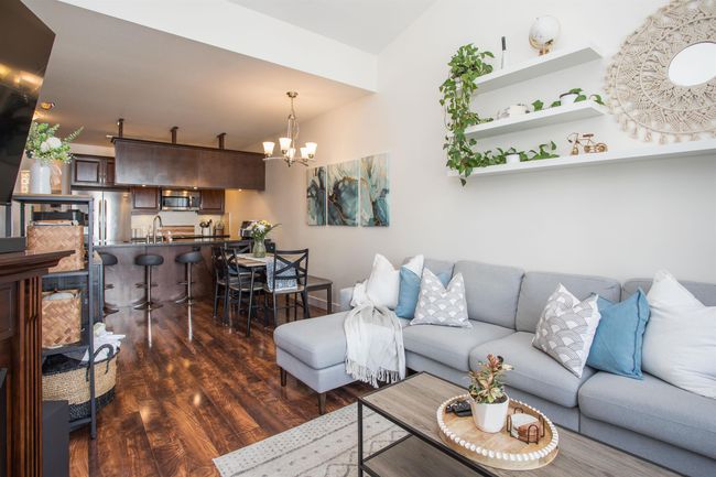 Living room with an inviting chandelier and dark wood-type flooring | Image 12