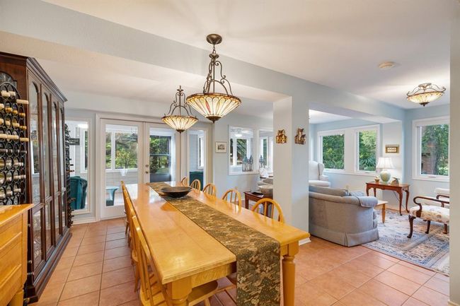 The dining space separates the kitchen and living room. The outdoor covered and screened patio is accessed through this space. | Image 29