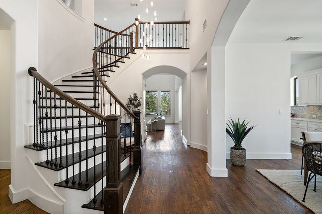 Entryway with arched stairway, dark wood-style floors, stairway, and a high ceiling | Image 19