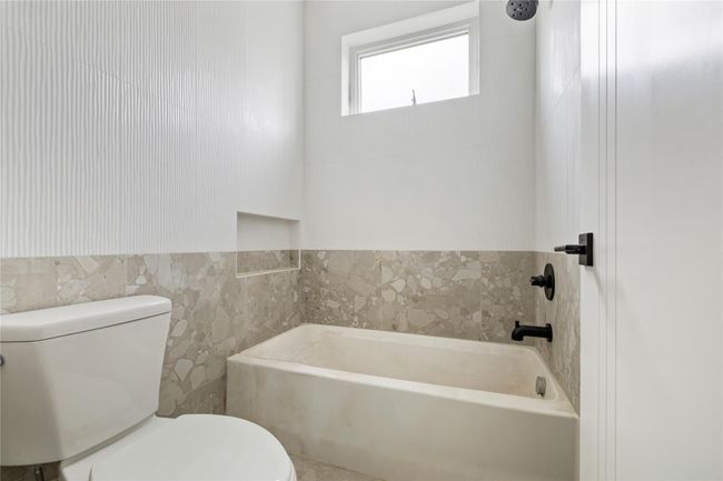 Bathroom with a bath, toilet, and tile walls | Image 28