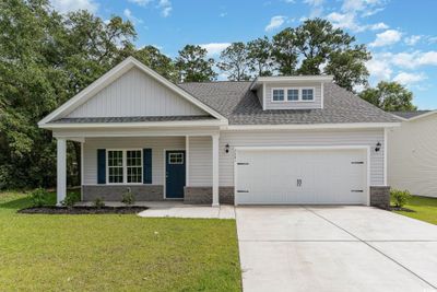 Craftsman-style home featuring a porch, a garage, and a front lawn | Image 1