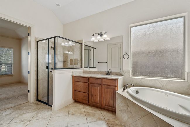Bathroom featuring plenty of natural light, vaulted ceiling, a garden tub, vanity, and a shower stall | Image 32