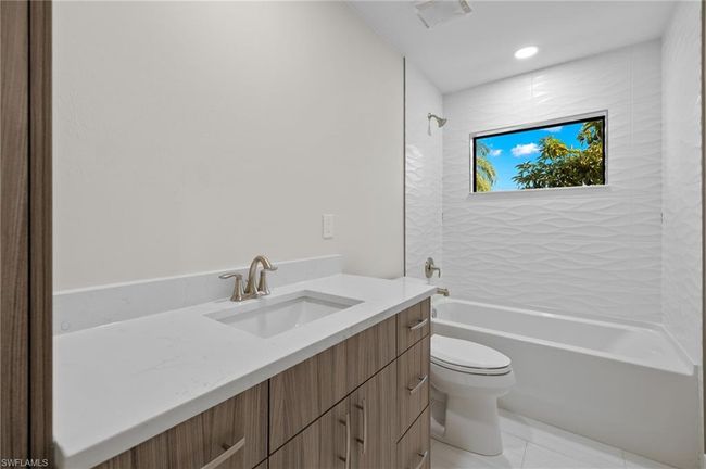 Full bathroom featuring tile patterned flooring, toilet, vanity, and tiled shower / bath | Image 31
