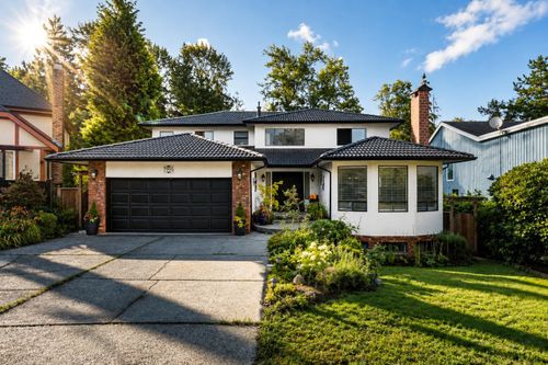 Contemporary two-story residence featuring a dark tiled roof and a white exterior | Card Image