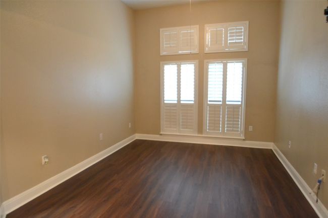 Empty room with dark wood-type flooring and baseboards | Image 15