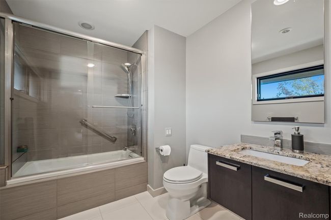 Bathroom with tiled shower / bath combo, vanity, and light tile patterned floors | Image 46