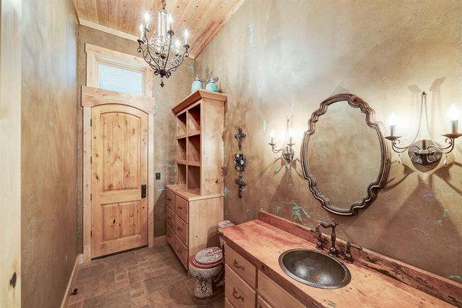 The other half bathroom leads to the backyard and has a custom designed painted toilet. | Image 35