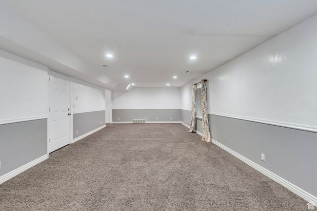 Finished basement with baseboards, recessed lighting, visible vents, and carpet | Image 23