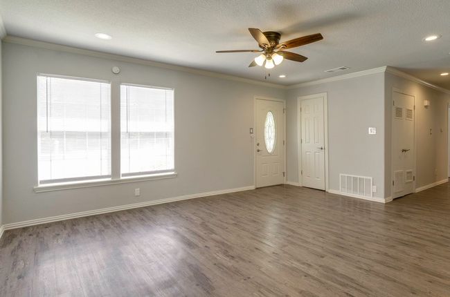 Foyer with dark wood finished floors, ceiling fan, a textured ceiling, ornamental molding, and recessed lighting | Image 8