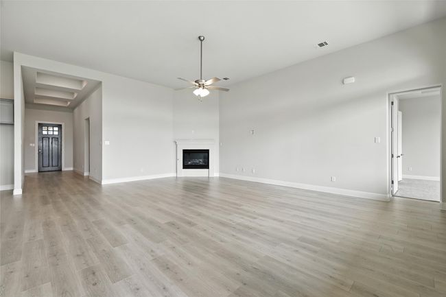 Unfurnished living room with ceiling fan, light wood-style flooring, and a glass covered fireplace | Image 13